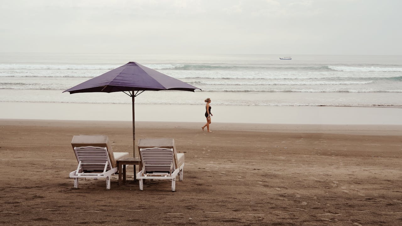 serene-beach-scene-with-lounge-chairs-and-umbrella-34696173